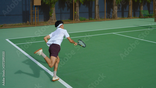 Фотография Professional tennis player performs forehand hit on clay tennis court