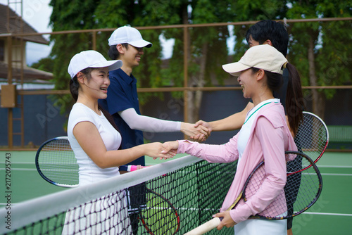 Photography Young Asian tennis players exchange friendly Shaking Hands Over Net after a doub