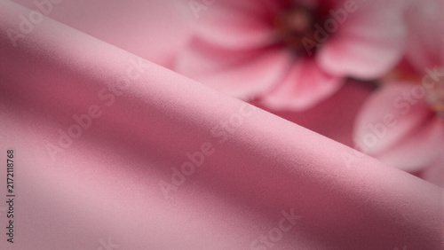 Soft pink fabric fold with blurred pink floral background
