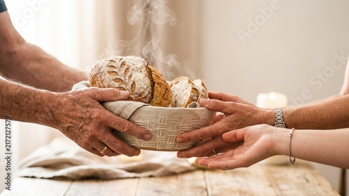 Family hands sharing warm fresh sourdough bread