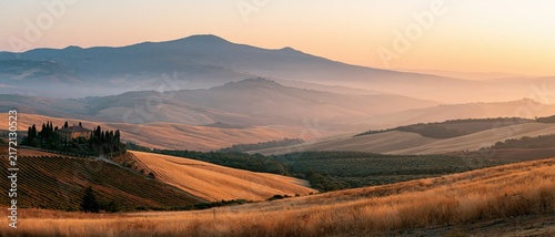 The Landscape of Tuscany's rolling hills bathed in golden hour light
