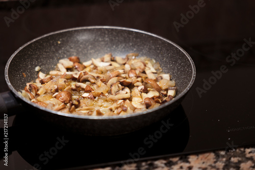 фотографія Sauteing portobello mushrooms and onion in frying pan.
