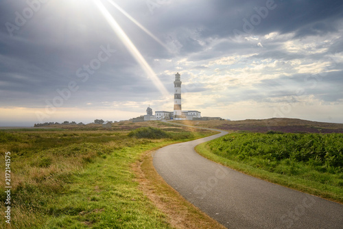 Route bitumée sinueuse, sous les rayons du soleil, menant au phare du creac'h  à l'ouest de l'île d'Ouessant en Bretagne, département du Finistere