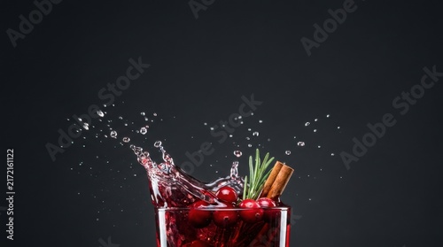 Dynamic Splash of Hot Mulled Wine with Cinnamon Sticks and Berries on Dark Background