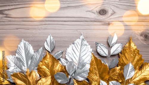 Festive Silver and Gold Decorative Leaves Over Rustic Wood Background with Warm Glowing Bokeh Lights for Holiday Greeting Card Design