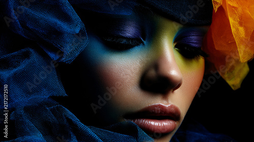 Artistic portrait of a woman with colorful makeup and fabric accessories, close-up