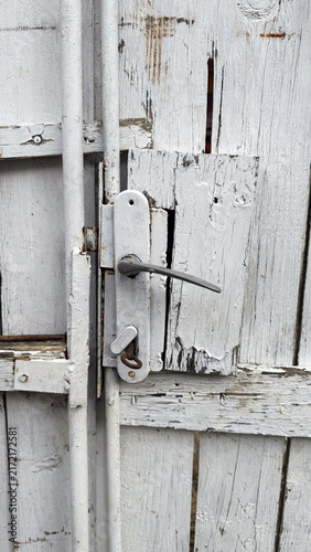  Weathered white painted wooden gate and rusty metal latch
