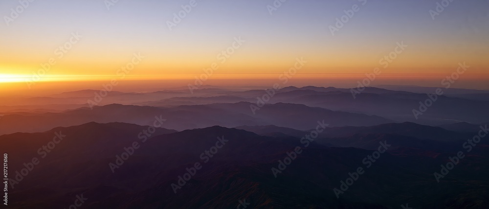 Obraz premium The Sunrise Over Misty Mountain Ridge at Dawn with Golden Horizon