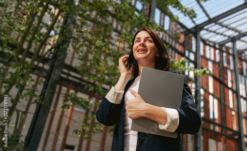 Businesswoman laughing during a phone call outdoors