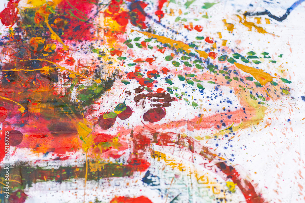 Naklejka premium Abstract colorful paint splatters on canvas. Creative artistic backdrop with red spots, blue brush strokes and green prints on white fabric background for modern art hobby concept.