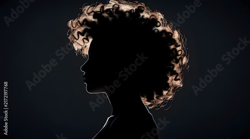 Silhouette profile of a woman with curly hair against a dark background.