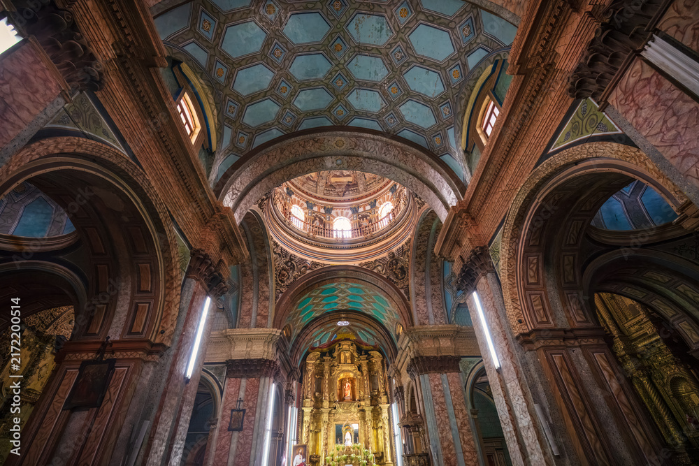 Obraz premium Gilded interior of the historic Church of La Compañía de Jesús (Iglesia de la Compañía de Jesús), showing the ornate gold leaf altarpiece, vaulted Mudéjar ceiling, and cupola in Quito, Ecuador.