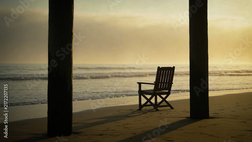 Lone chair on an empty beach with calm ocean view, peaceful summer landscape