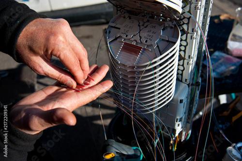 Fotografie Technician hands installing fiber optic telecommunications cables
