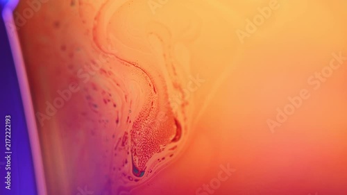 Warm golden fluid film plane with red marbling swirl and blue rim border. Warm golden and orange backlighting illuminates a wide liquid film plane in low-key macro perspective