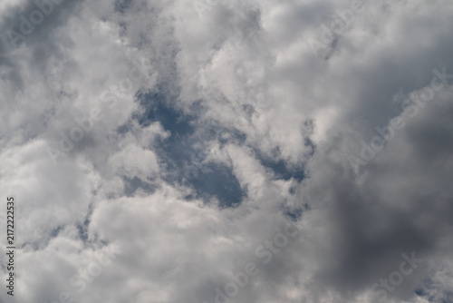 Canvastavla Soft billowy clouds dance across a moody sky revealing glimpses of blue in the l