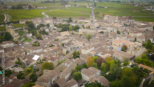 Aerial view of the historic village of Saint-Emilion with its iconic monolithic church, stone rooftops, and surrounding vineyards in Saint-Emilion, Nouvelle-Aquitaine, France.