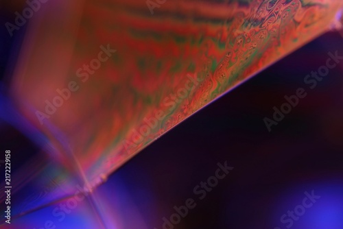 Foto Iridescent crimson and green fluid film plane with violet backlight and geometric vertex