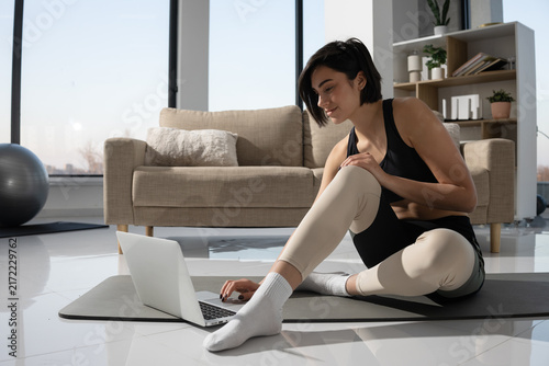 Woman using laptop for online fitness class at home