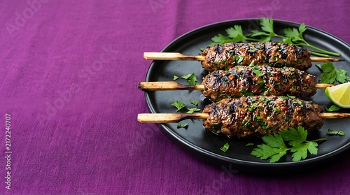 Delicious grilled meat skewers garnished with sesame seeds and fresh parsley served on a dark plate