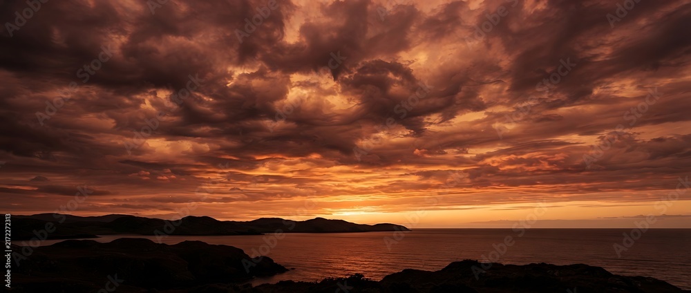 Fototapeta premium sunset over the river , Dramatic Fiery Sunset Sky Over Calm Ocean and Coastal Hills Landscape
