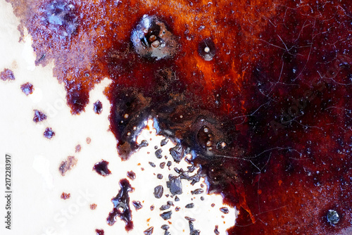 Abstract Burgundy and Orange Liquid Texture on Paper. Close-up abstract photograph of rich burgundy, deep red, orange, and brown liquid pigments spread across textured paper.