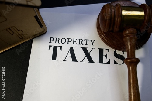 Wooden gavel resting on a property taxes document
