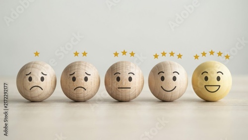 Five wooden spheres with facial expressions and star ratings in a row