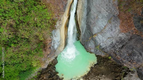 Overhead aerial view of turquoise plunge pool and rock walls at Mangku Sakti waterfall Lombok