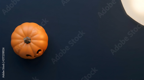 Dramatic still life of a carved pumpkin and a full moon on a dark background