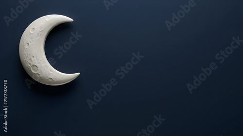 A decorative crescent moon sculpture against a dark navy blue textured background