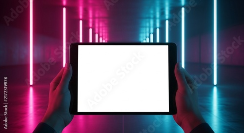 Hands Holding Tablet Computer with Blank White Screen in Futuristic Corridor with Pink and Blue Neon Lights Glowing in Background