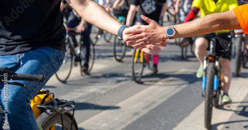 Фотография Close-Up of Cyclists Reaching Out to High Five During a City Bike Ride