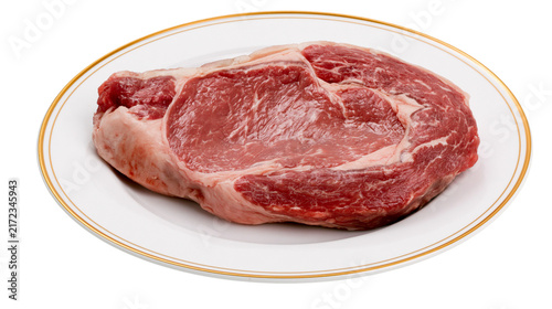 Photography Raw marbled ribeye steak on a white plate with gold trim, isolated on transparen