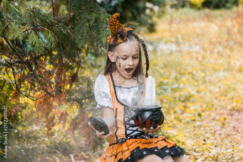 Foto Girl Enjoys Halloween Activities in Autumn With Pumpkins and Spiderwebs on a Sun