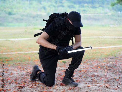 Bild auf Leinwand Security guard man or mercenary or private bodyguard and defender in black uniform stay at forest and rock mountain for security tactical fieldwork or outdoor training