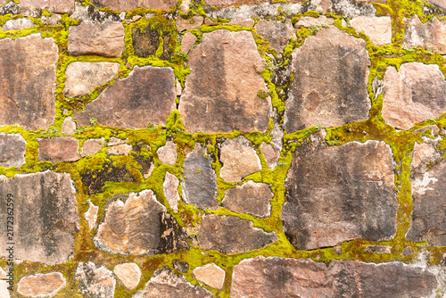 Foto Moss covered stone wall texture with natural irregular pattern