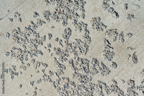 Weathered concrete surface with exposed stone aggregate.