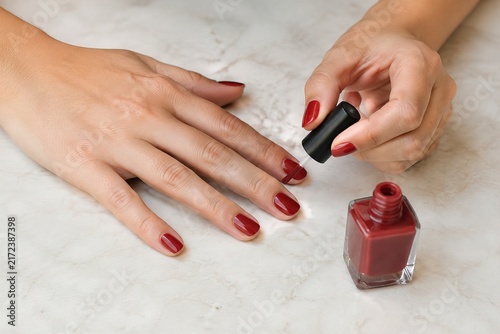 manicure, a woman polishing and coloring her nails