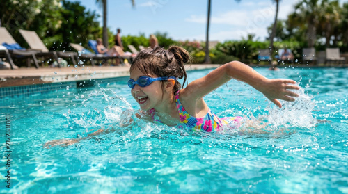 Joyful Girl Swimming in Outdoor Pool on Sunny Day