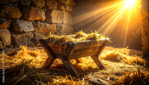 This empty wooden manger with straw sits inside a rustic stone stable illuminated by divine  warm golden light rays  evoking hope and peace for Christmas. There are no people.
