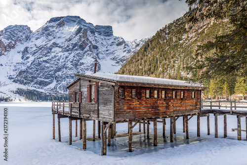 Foto Lake Braies (Pragser See) in South Tyrol in winter, view of snowy mountain and Lake, Snow-covered wooden hut on stilts beside frozen lake