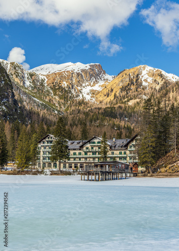 Quadro su tela Lake Braies (Pragser See) in South Tyrol in winter, view of snowy mountain and Lake, Frozen lakefront hotel under snow-capped mountains