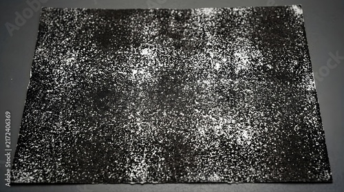 White salt sprinkled on a dark black textured background surface