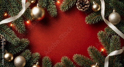 Christmas Frame with Pine Branches and Gold Ornaments on Red Background