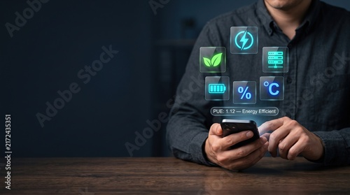 Data center energy efficiency concept with professional using smartphone beside glowing power, eco, server, temperature and battery icons, sustainable infrastructure with clean left copy space