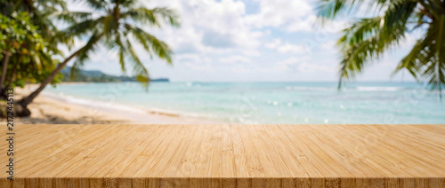 Wooden table in front of a beach with palm trees and ocean view