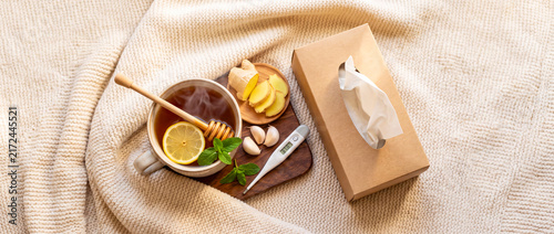 Warm drink and tissues on a cozy blanket during a cold day