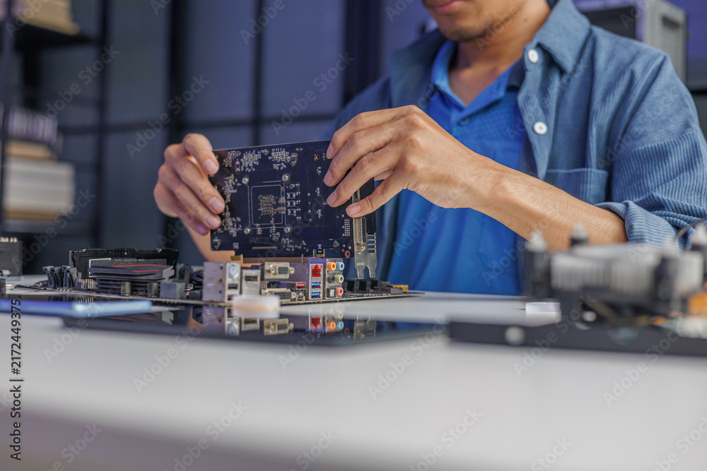 Naklejka premium Close-up of electronic technician hands working on computer mainboard repair.