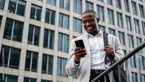 Real estate agent, black businessman, using smartphone, calling, outdoor near office building. African business man smiling, prepared for client meeting, leading cross-functional projects. Copy space